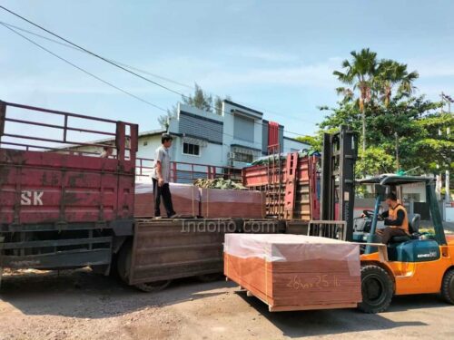 Tim PT. INDOHO sedang melakukan pemuatan Triplek Phenolic Film Face menggunakan forklift untuk pengiriman cepat ke lokasi proyek.